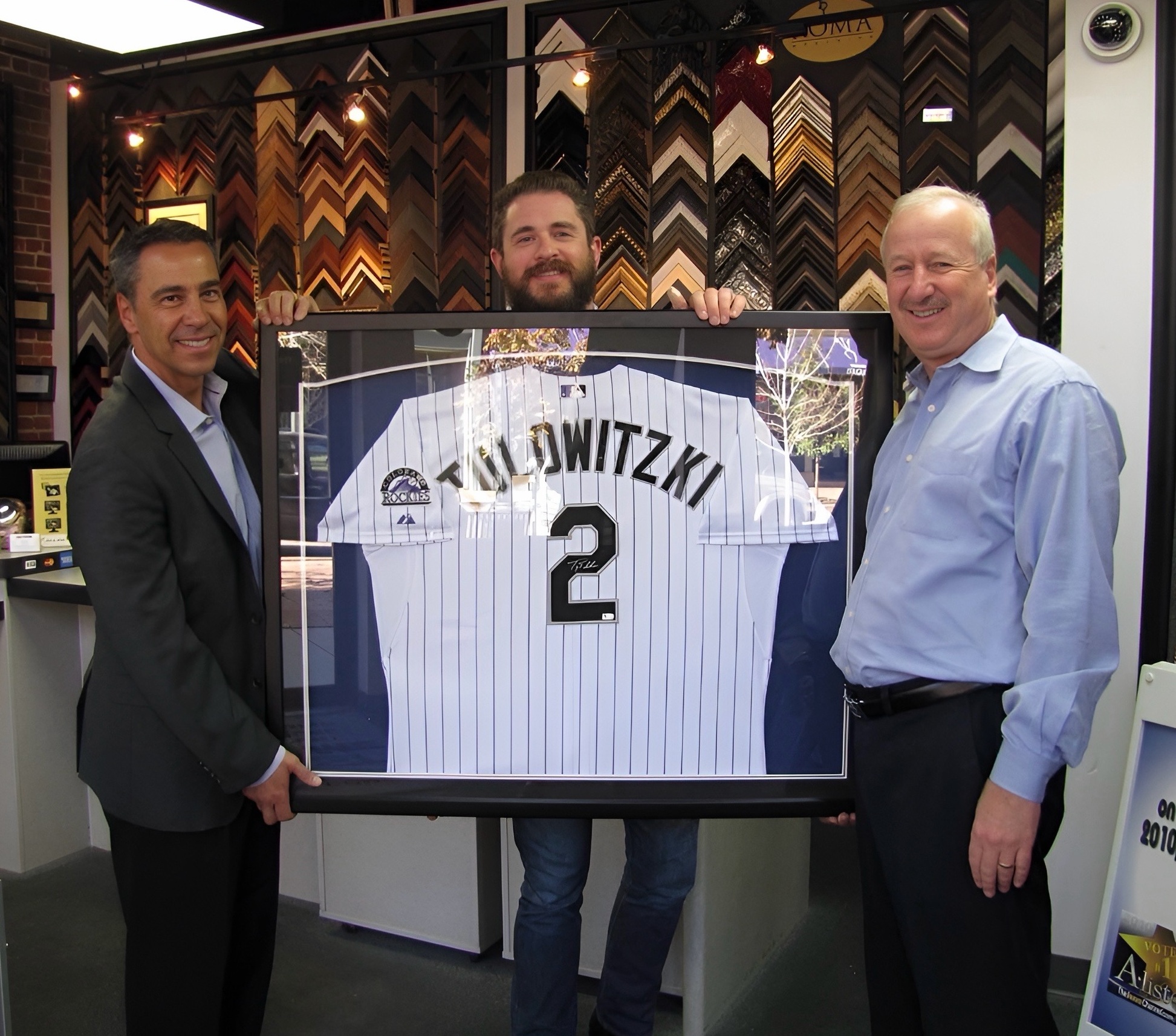 Jim Kellogg and David Eisner holding a custom framed Troy Tulowitzki Colorado Rockies jersey